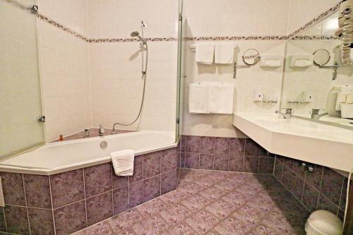 a bathroom with a tub and a sink at Landhotel Krausnick in Krausnick