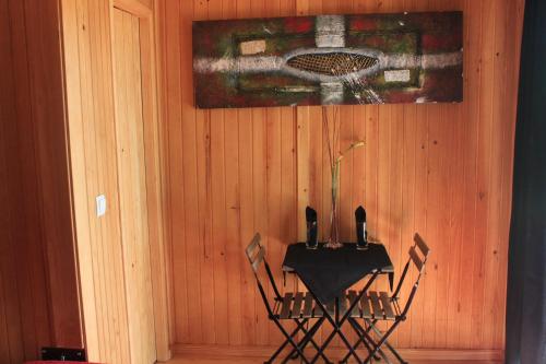 a table and chairs in a room with a painting at Hotel Douro Vale de Campos in Penafiel