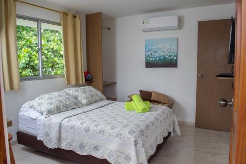 een slaapkamer met een bed met een gele schoen erop bij Cabañas Green Yard in San Andrés