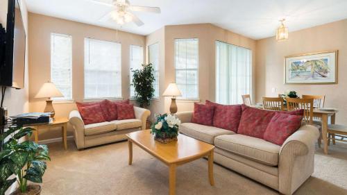a living room with two couches and a table at Disney's Den - Closer to all the fun! in Davenport