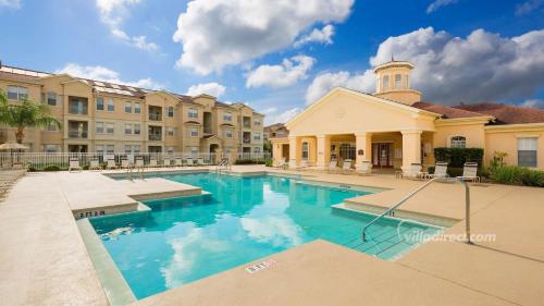 a swimming pool in front of a building at Disney's Den - Closer to all the fun! in Davenport