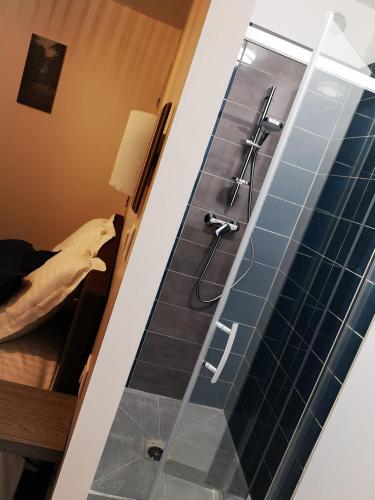 une salle de bain avec douche aux carreaux bleus dans l'établissement Hôtel/Restaurant C'Vall, à Urepel