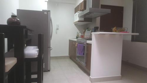 a kitchen with a white counter and a refrigerator at Division del Norte Rooms in Mexico City
