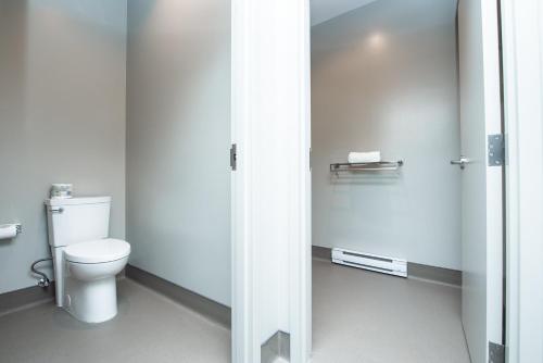 a bathroom with a white toilet in a stall at Nowhere Special Hostel in Rossland