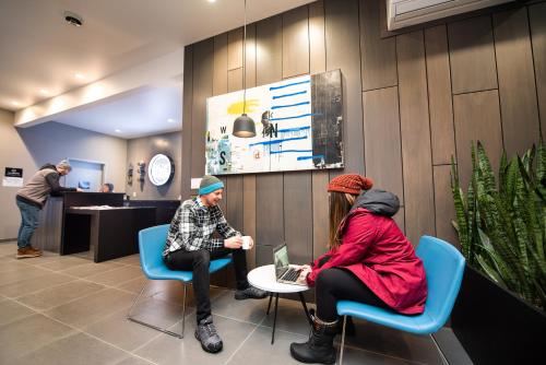 two people sitting in chairs in a waiting room at Nowhere Special Hostel in Rossland