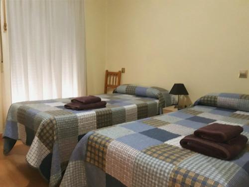 ログローニョにあるCálfred Junto a Parque Gallarzaのベッドルーム(ベッド3台、シーツ付)