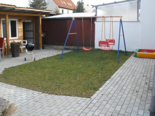a playground with two swings in a yard at Ferienwohnungen Flora in Bad Windsheim
