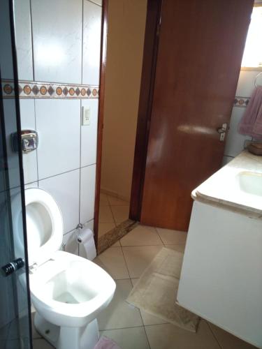 a bathroom with a toilet and a sink at Recanto do Bem-Te-Vi in Olímpia