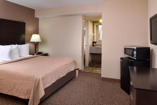 a hotel room with a bed and a bathroom at Airport Inn in Nederland