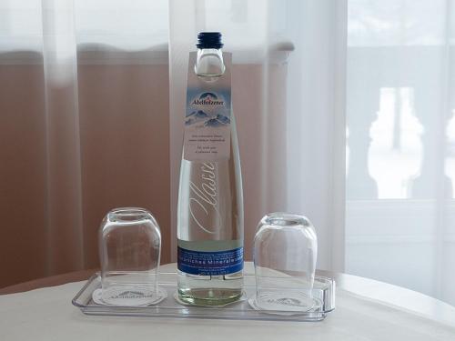 a bottle and two glasses sitting on a tray at Gästehaus Florian in Tegernsee