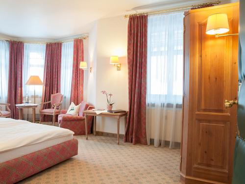 une chambre d'hôtel avec un lit, une table et des chaises dans l'établissement Gästehaus Florian, à Tegernsee