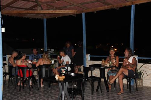 a group of people sitting at tables on the beach at night at Nosso Lounge Hostel in Florianópolis