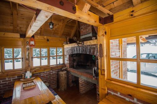 Una sala de estar con chimenea en una cabaña de troncos en Mountain House Tadić 2, en Bajina Bašta
