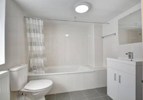 a white bathroom with a toilet and a sink at The Pearl - Stylish 3 Bedrooms house in great central location in Brighton & Hove