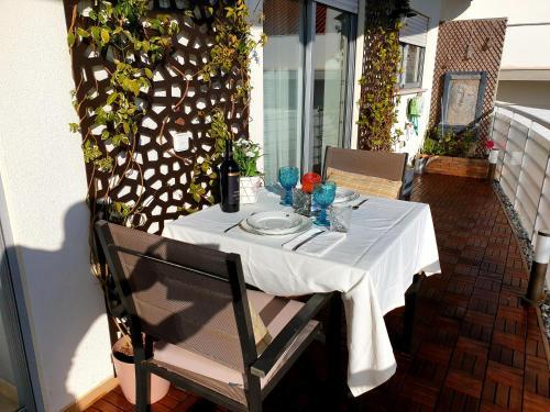 une table avec un tissu de table blanc sur une terrasse dans l'établissement SunHouse Room, à Albufeira