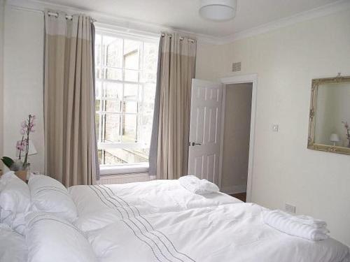 un letto bianco in una camera da letto con finestra di Kirkmay House a Crail