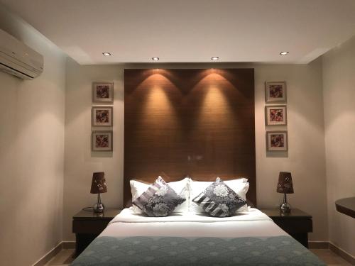 1 dormitorio con 1 cama con cabecero grande en ذرا للأجنحة الفندقية 2, en Al Bukayriyah
