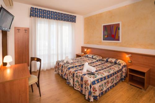 Habitación de hotel con cama y escritorio en Hotel Antille e Azzorre, en Lido di Jesolo