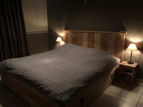 a bedroom with a large bed with two lamps at Kampenhof in Maaseik