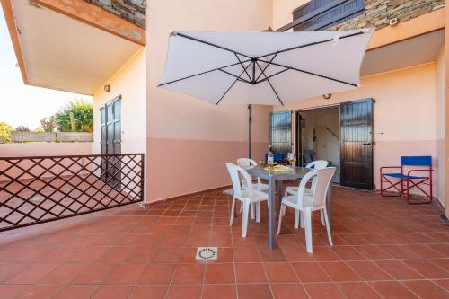 a patio with a table and chairs and an umbrella at Apartments Stintino - Insel Sardinien 23216 in Villa Sirena