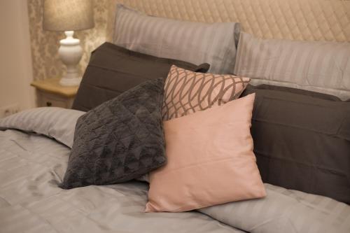 a pile of pillows sitting on a bed at Křišťanka - kouzelné apartmány in Prachatice