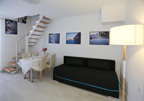 a living room with a black bed and a table at Tomas Art & Tomas Cave in Split