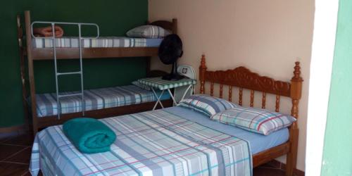 a bedroom with two bunk beds with a child sleeping on them at Pousada Pontal do Moleque in Carrancas