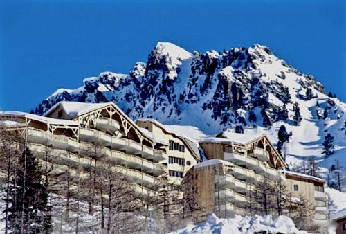 um edifício na neve com uma montanha ao fundo em Les terrasses d azur em Isola 2000