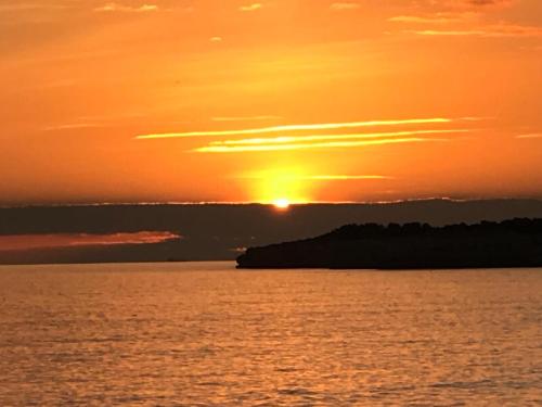 a sunset over the water with the sun in the sky at Modern apartment@Armação de Pêra in Armação de Pêra