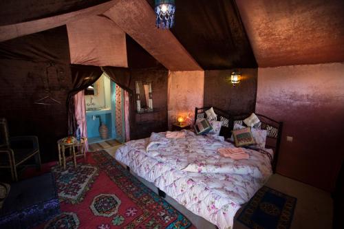 a bedroom with a large bed in a room at Auberge Sahara Garden in Lac Yasmins