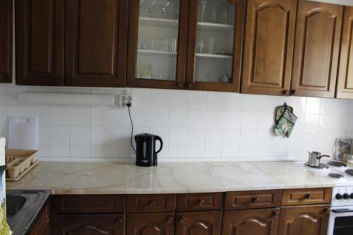 a kitchen with wooden cabinets and a counter top at Two bedroom apartment near centre in Ohrid