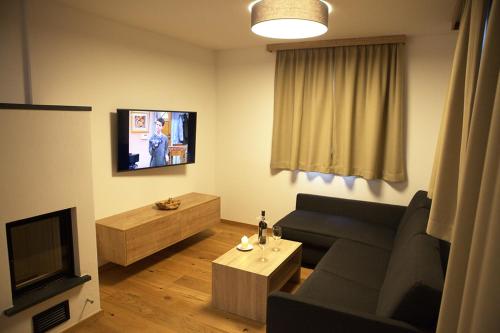 a living room with a couch and a tv at Kitzbuheler Alpen Residenz Top2 Hollersbach in Hollersbach im Pinzgau