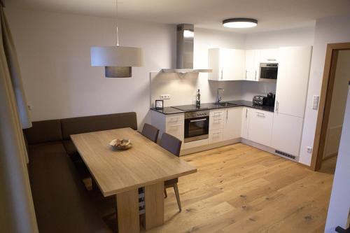 a kitchen with a wooden table and a wooden floor at Kitzbuheler Alpen Residenz Top2 Hollersbach in Hollersbach im Pinzgau