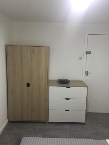 um quarto com um armário de madeira e uma cómoda em Sama's Stylish Room 5 em Manchester