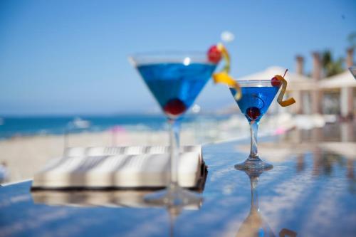 two martini glasses sitting on a table near the beach at Krystal Vallarta in Puerto Vallarta