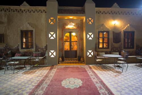 a room with tables and chairs in a building at Auberge Sahara Garden in Lac Yasmins