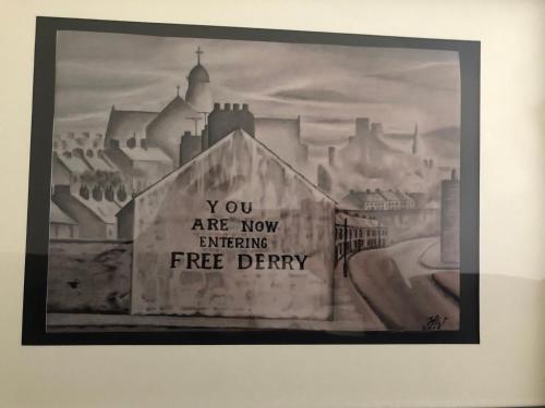 a painting of a city with a sign that reads you are now entering free entry at bishop gate bnb in Derry Londonderry