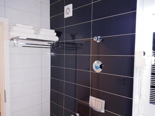 a bathroom with a black and white tiled shower at Dream Apartment Brasov - West in Braşov