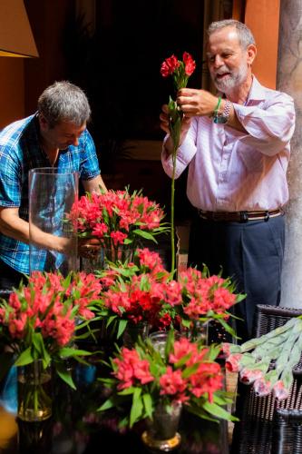 two men looking at a display of red flowers at Hotel Casa Del Poeta in Seville