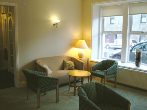 a living room with a couch and chairs and a table at St Clair Hotel in Thurso