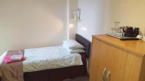 a bedroom with a bed and a wooden dresser at Tudor Rose Hotel in Blackpool