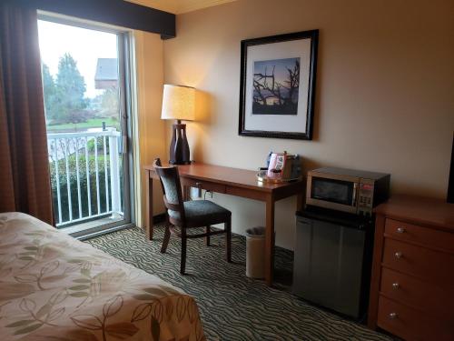 a hotel room with a desk and a bed and a window at Three Rivers Casino Resort in Florence