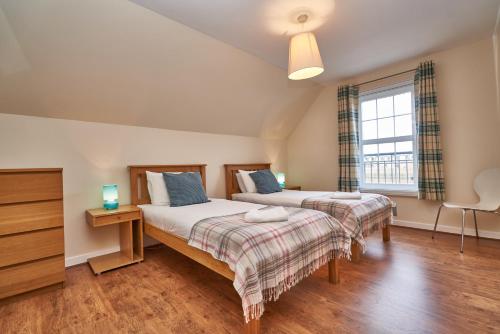 a bedroom with two beds and a window at Castle Apartments in Edinburgh