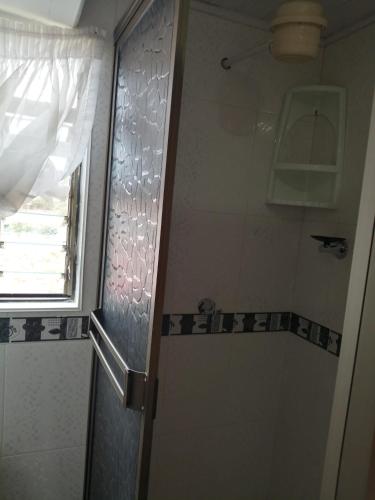 a shower with a glass door in a bathroom at Hospedaje El Mirador in Iza