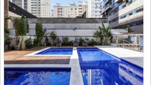 a swimming pool on the side of a building at Flat Capitania Varam in Guarujá