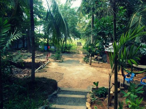a path in a garden with a bunch of trees at Hidden Well Hiriketiya in Hiriketiya