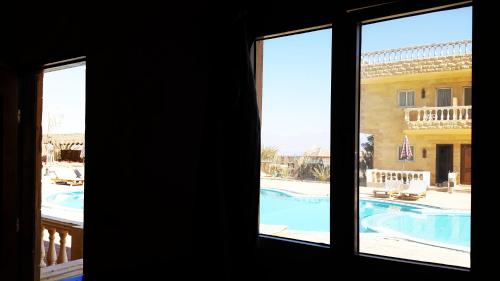 a window with a view of a swimming pool at Ciao Hotel in Nuweiba