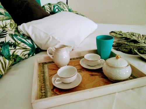 a tray with three cups and saucers on a bed at Turquesa de Sevilla Suite in Seville