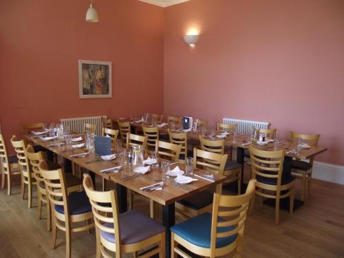 a large dining room with a long table and chairs at Raasay House Hotel in Raasay
