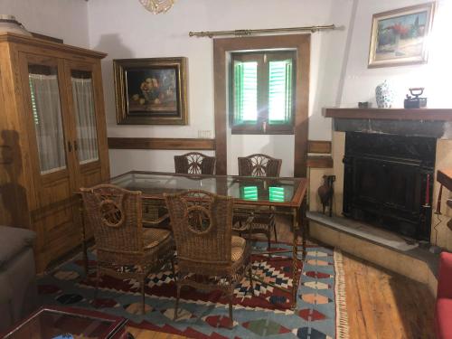 sala de estar con mesa, sillas y chimenea en Main House “El Estanco 14”, en Vega de San Mateo